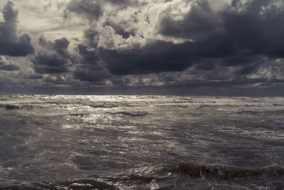 Scenic view of sea against storm clouds