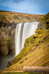 Scenic view of waterfall against sky