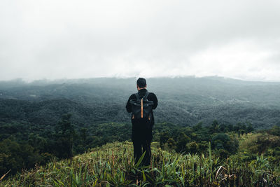 Man standing on mountain against sky