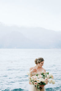 Portrait of young woman standing in sea