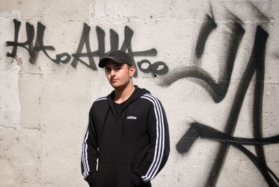 Young man standing against wall
