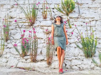 Portrait of woman standing against wall