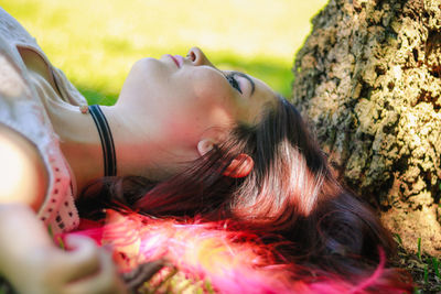 Close-up of young woman lying on field at park