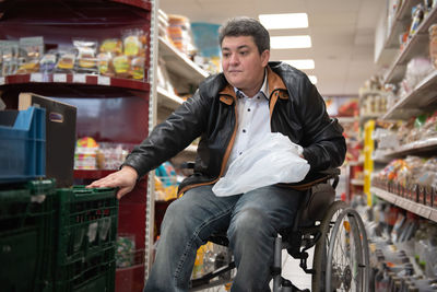 A disabled person in a wheelchair buys groceries