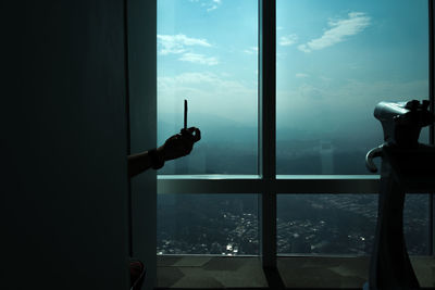 Close-up of man against sea seen through window