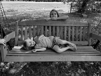 Portrait of woman lying on bench