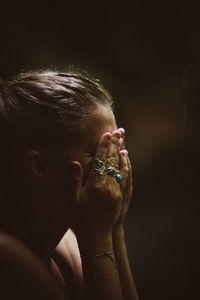 Close-up portrait of woman against black background