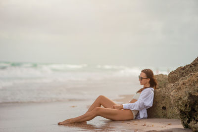 Young woman sitting at beach