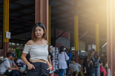 Portrait of woman standing at railroad station platform