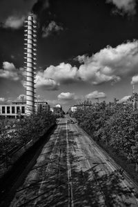 Railroad tracks amidst buildings in city against sky