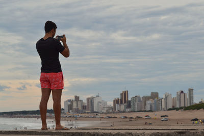 Side view of woman standing at beach