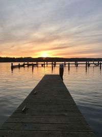 Pier on lake against sky during sunset