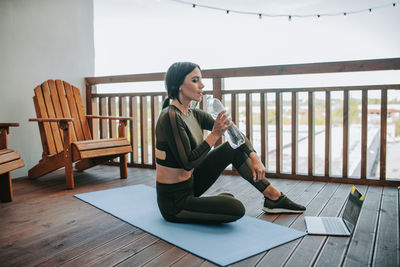 Full length of woman sitting on table