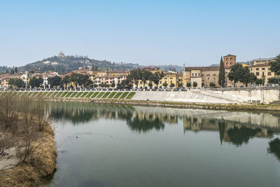 The bank of the adige in verona with buildings that are reflected on the water