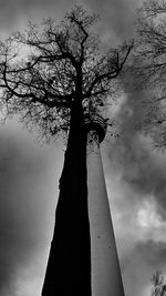 Low angle view of bare tree against cloudy sky