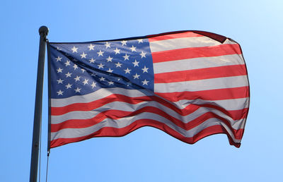 Low angle view of flag against blue sky