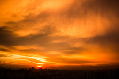 Silhouette landscape against dramatic sky during sunset