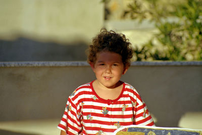 Portrait of boy standing against wall