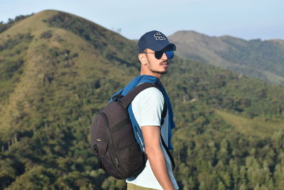 Close-up man standing on mountain against sky