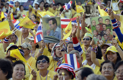 High angle view of people with picture frame and thai flags at event