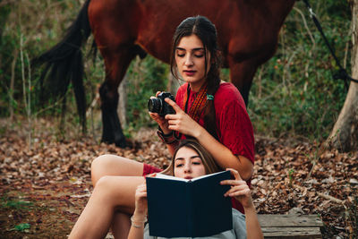 Young woman photographing while using phone