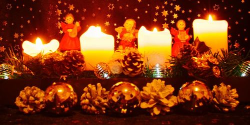 Close-up of lit candles burning at night