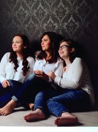 Mother sitting with daughters on floor at home