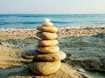 Stack of stones on beach against sky