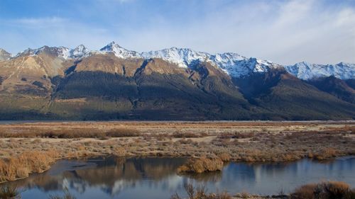 Calm lake against mountain range