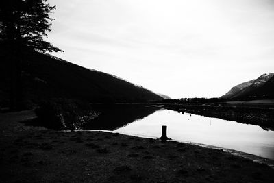 Scenic view of lake by mountain against sky