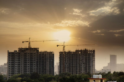 Buildings in city against sky during sunset