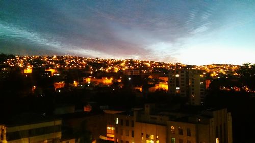 Illuminated cityscape against sky at night