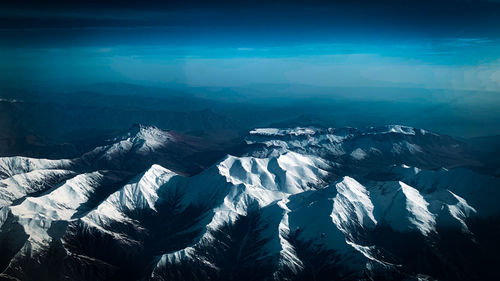 Aerial view of snowcapped mountains against sky