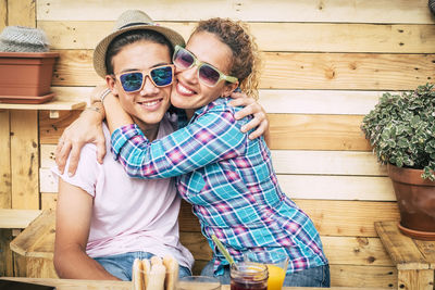 Mother and son embracing while sitting by food on table