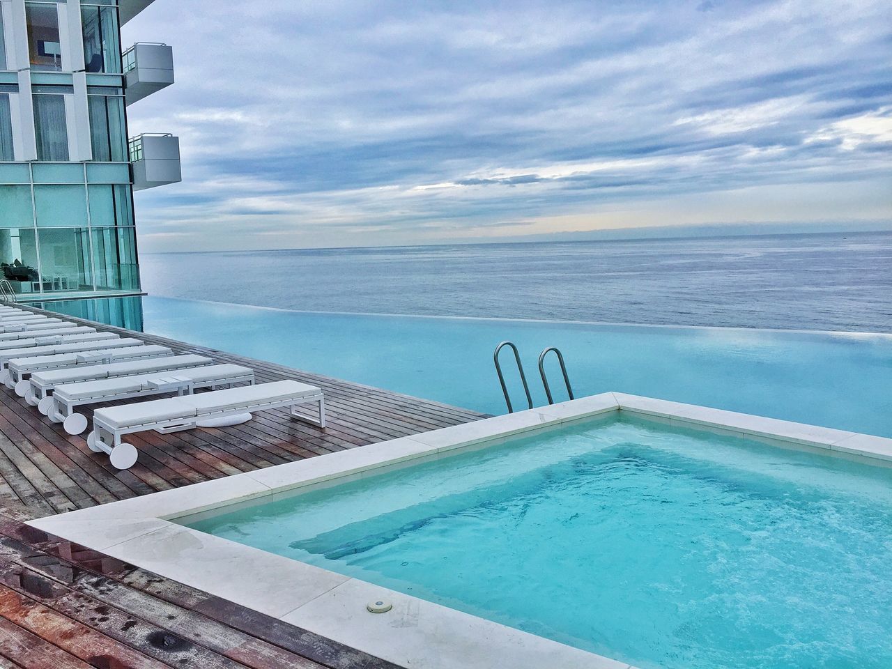 sea, water, sky, horizon over water, cloud - sky, blue, built structure, architecture, cloud, turquoise colored, scenics, tranquility, swimming pool, nature, building exterior, tranquil scene, beauty in nature, railing, cloudy, day