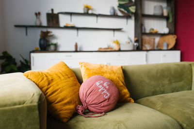 Bright pillows on the green sofa in the living room. cozy interior of the house