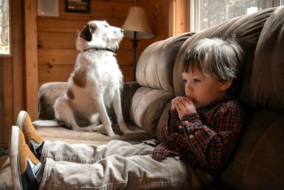 Full length of man with dog on bed