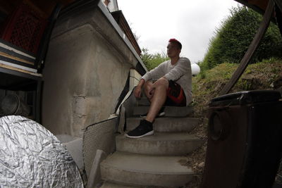 Full length of man sitting on wall