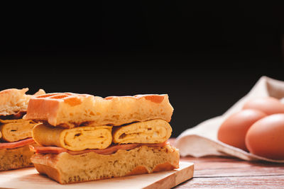 Close-up of bread on table against black background