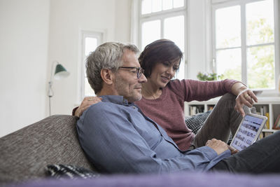 Mature couple at home on the sofa sharing tablet