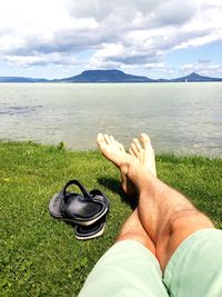 Low section of man in sea against sky