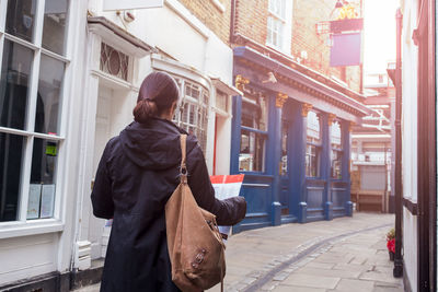 Rear view of man standing on footpath