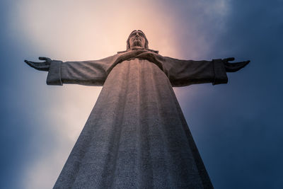 Jesus christ statue under stormy sky.