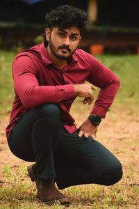 Portrait of young man sitting on field