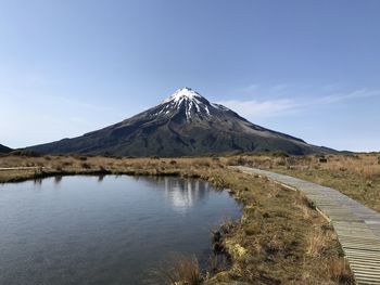 Scenic view of lake and mountains against blue sky