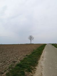 Road amidst field against sky