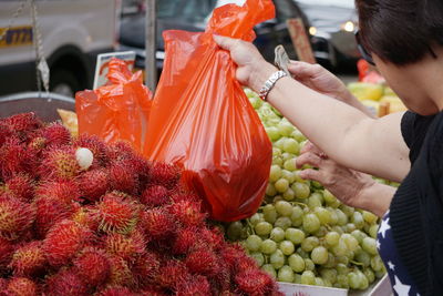 Women buying fruits from market stall