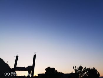 Silhouette of trees against clear blue sky