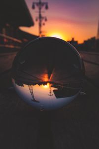 Close-up of sunglasses against sky at sunset