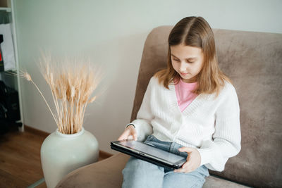 Girl teenager uses tablet learning home